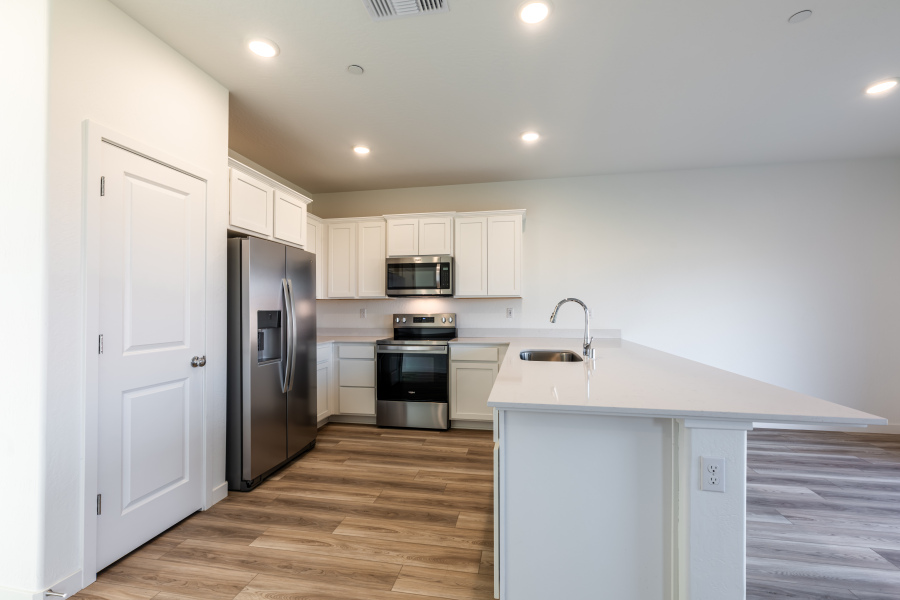 A kitchen with white cabinets.