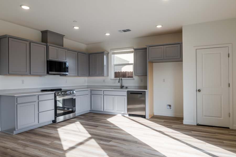 A kitchen with white cabinets.