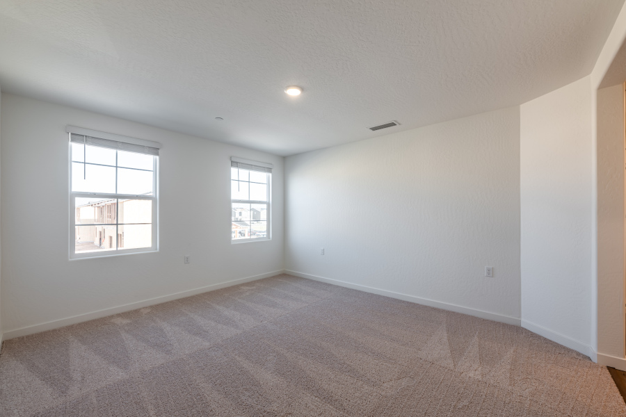 A room with a carpet and windows.