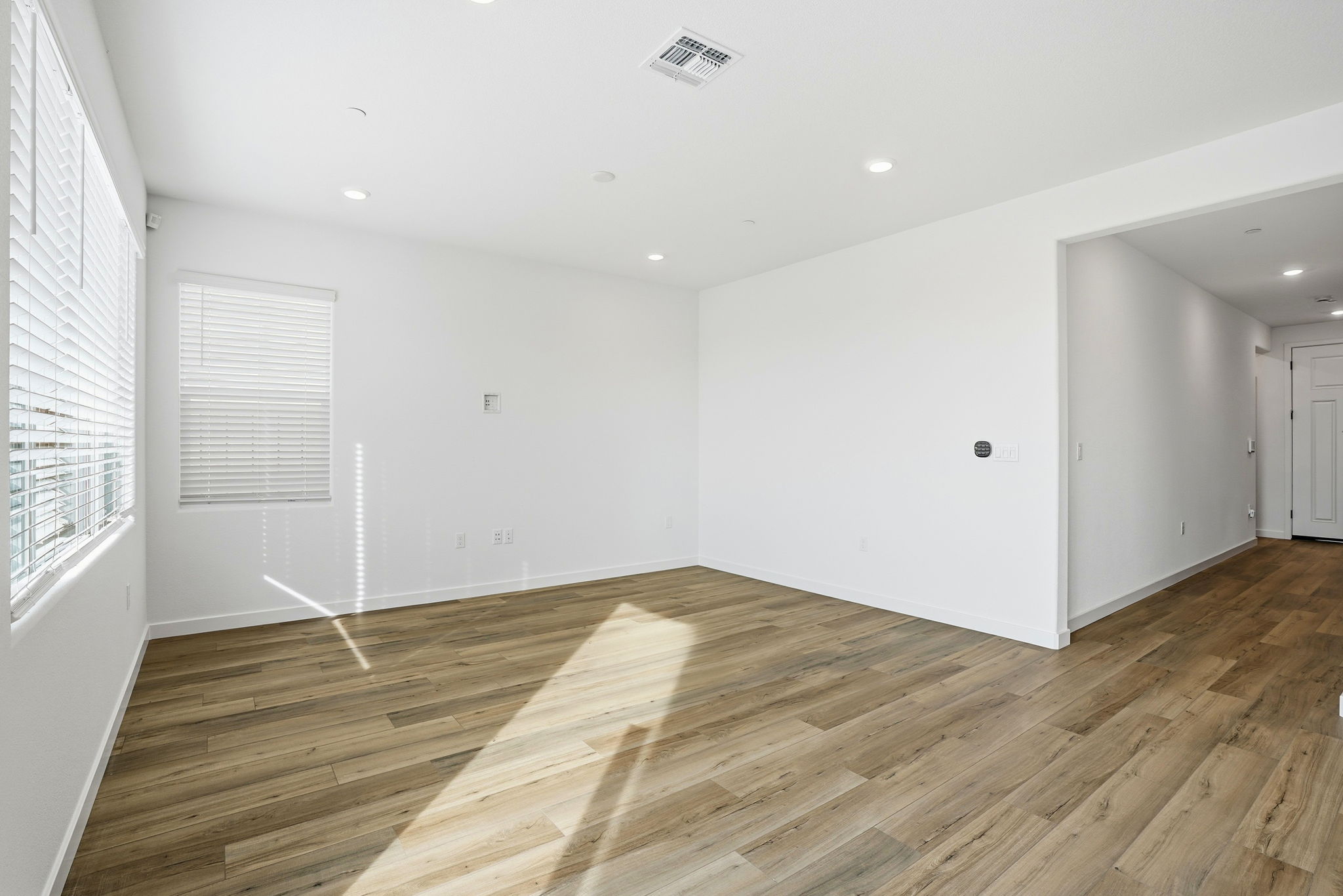 A room with a wood floor and white walls.
