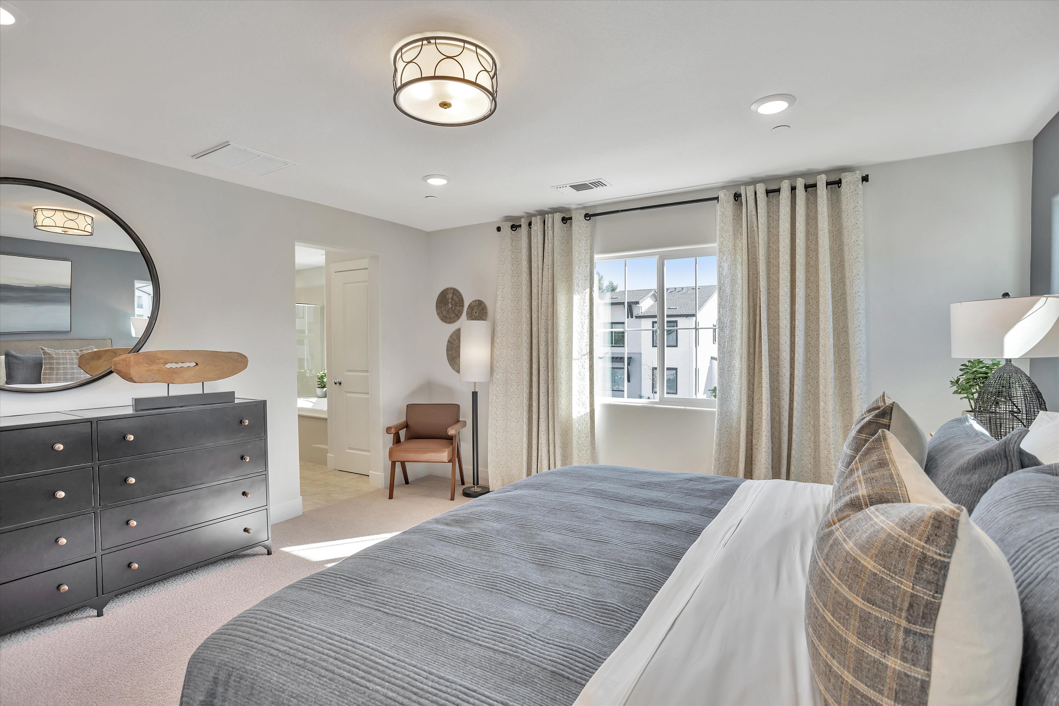 A bedroom with a bed and a mirror.