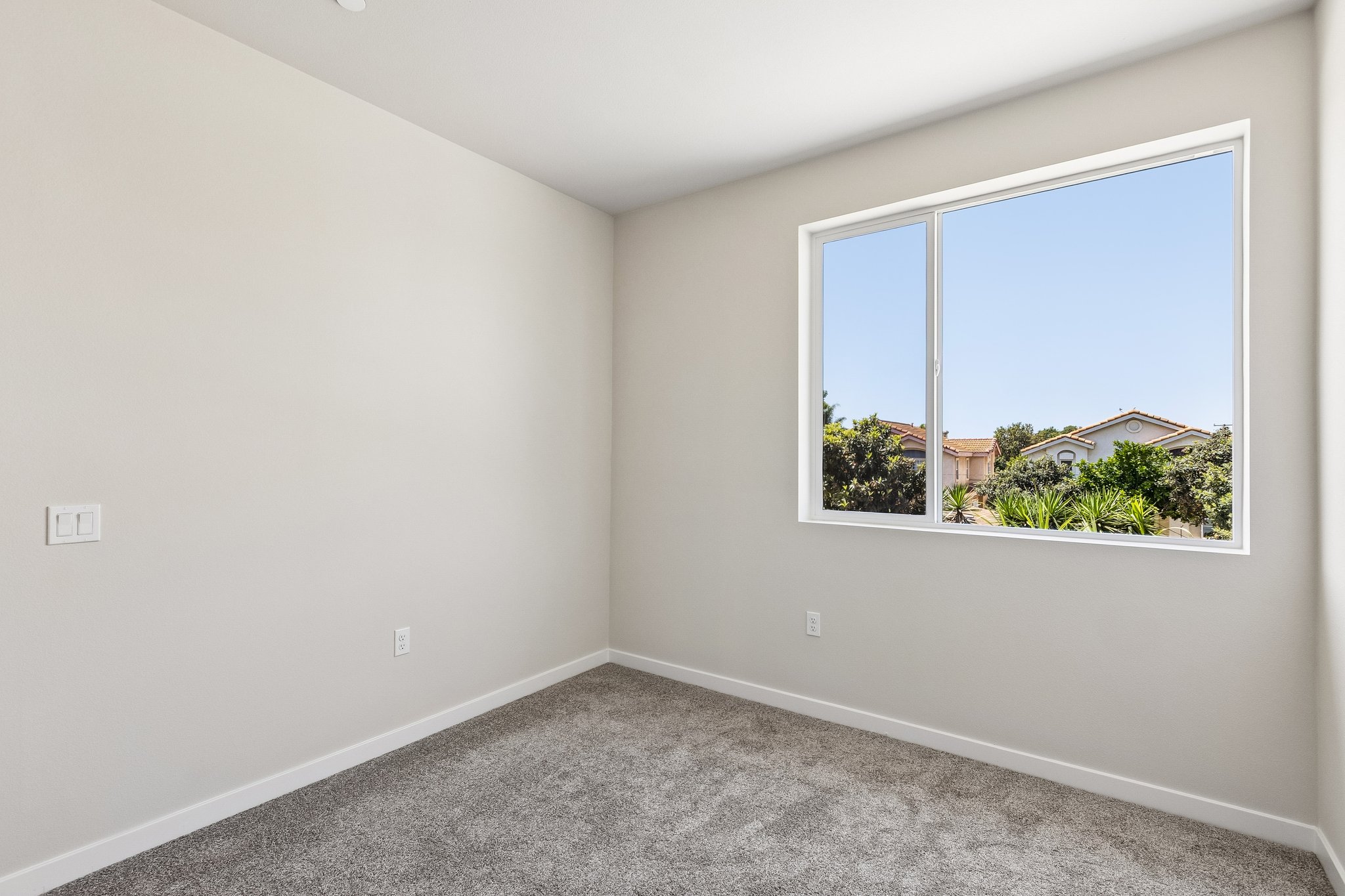 A room with a window and a carpet.