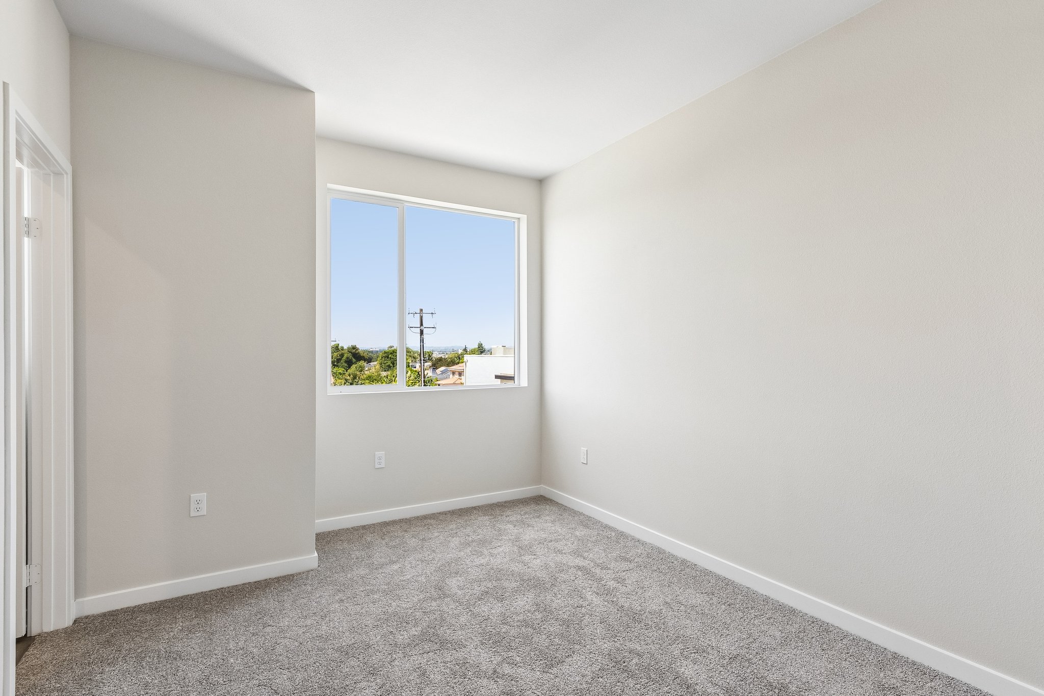 A room with a window and a carpet.