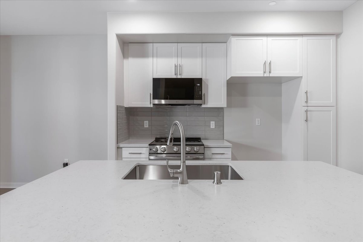 A kitchen with white cabinets.