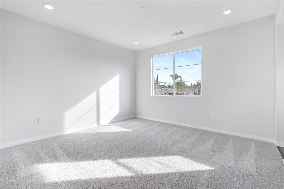 A room with a rug and a window.