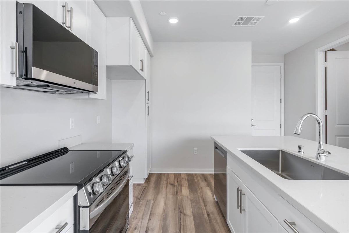 A kitchen with white cabinets.