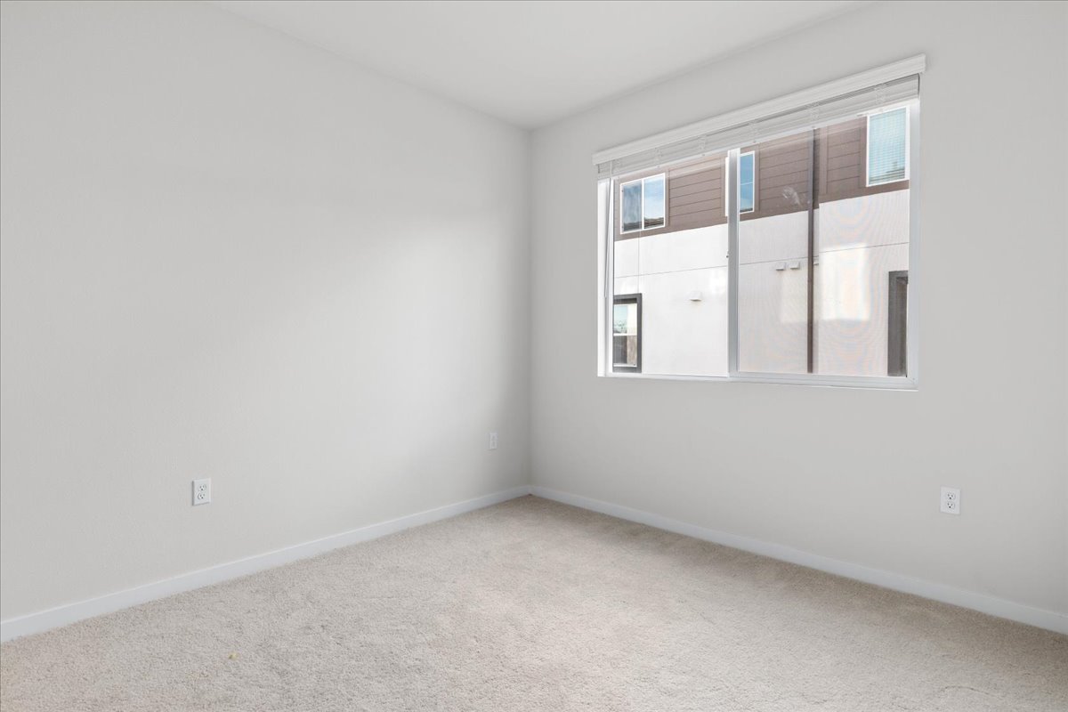 A room with a window and a white wall.