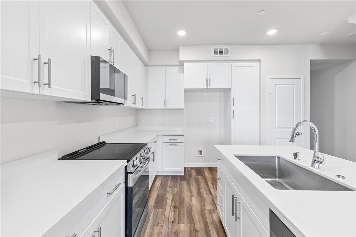 A kitchen with white cabinets.