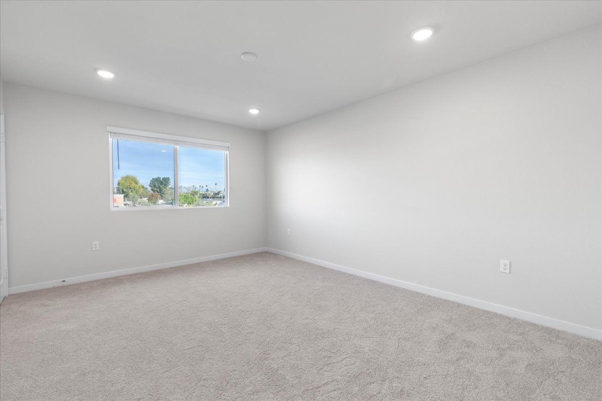 A room with a window and a white wall.