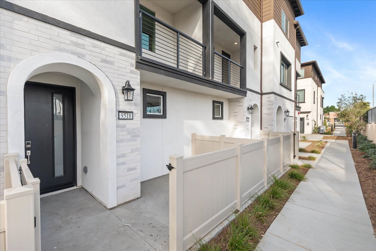 A white building with a white fence.