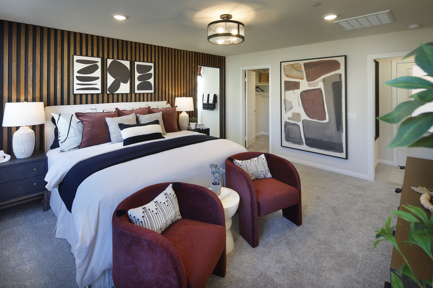 A bedroom with a bed and chairs.