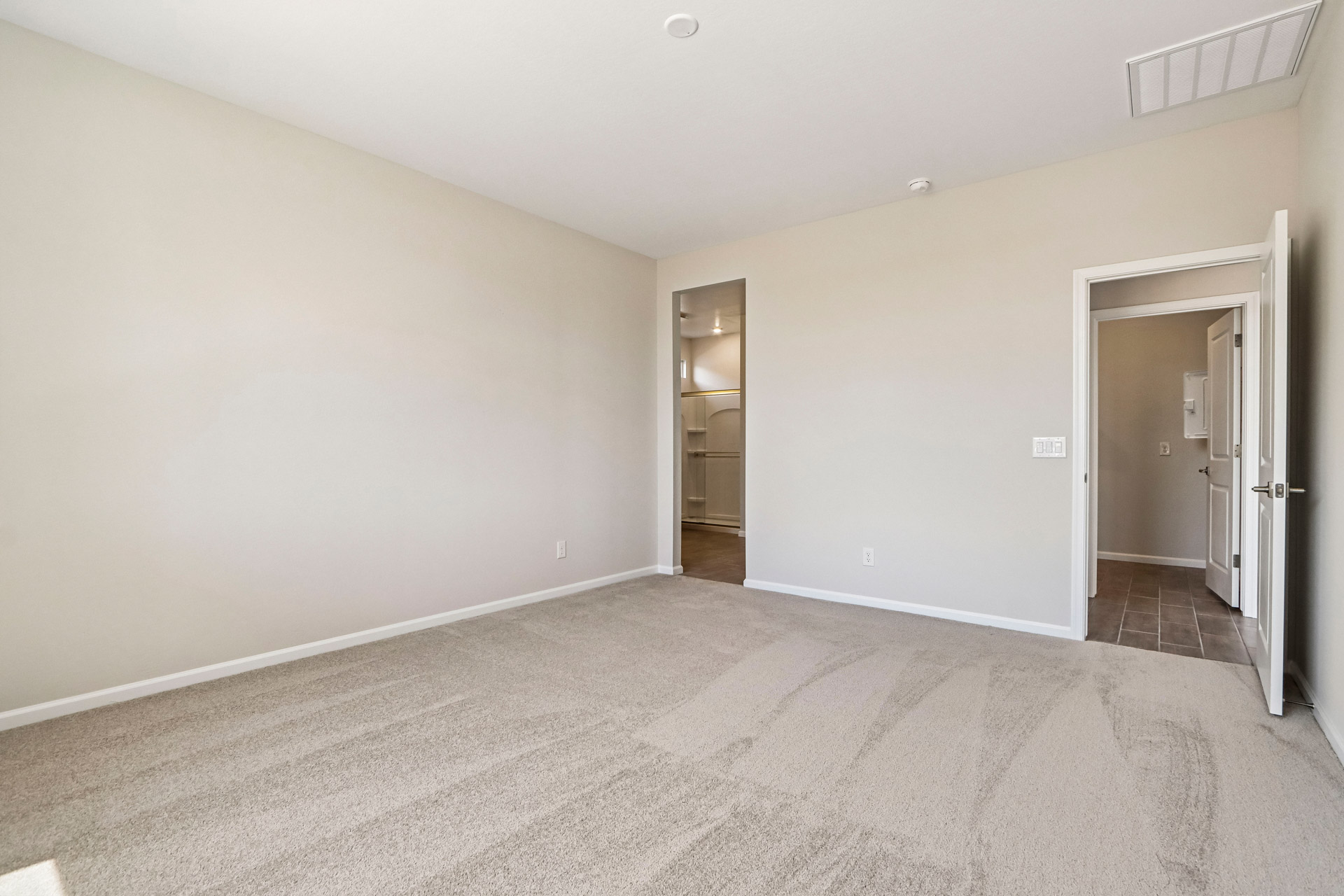 A room with a carpet and a door.