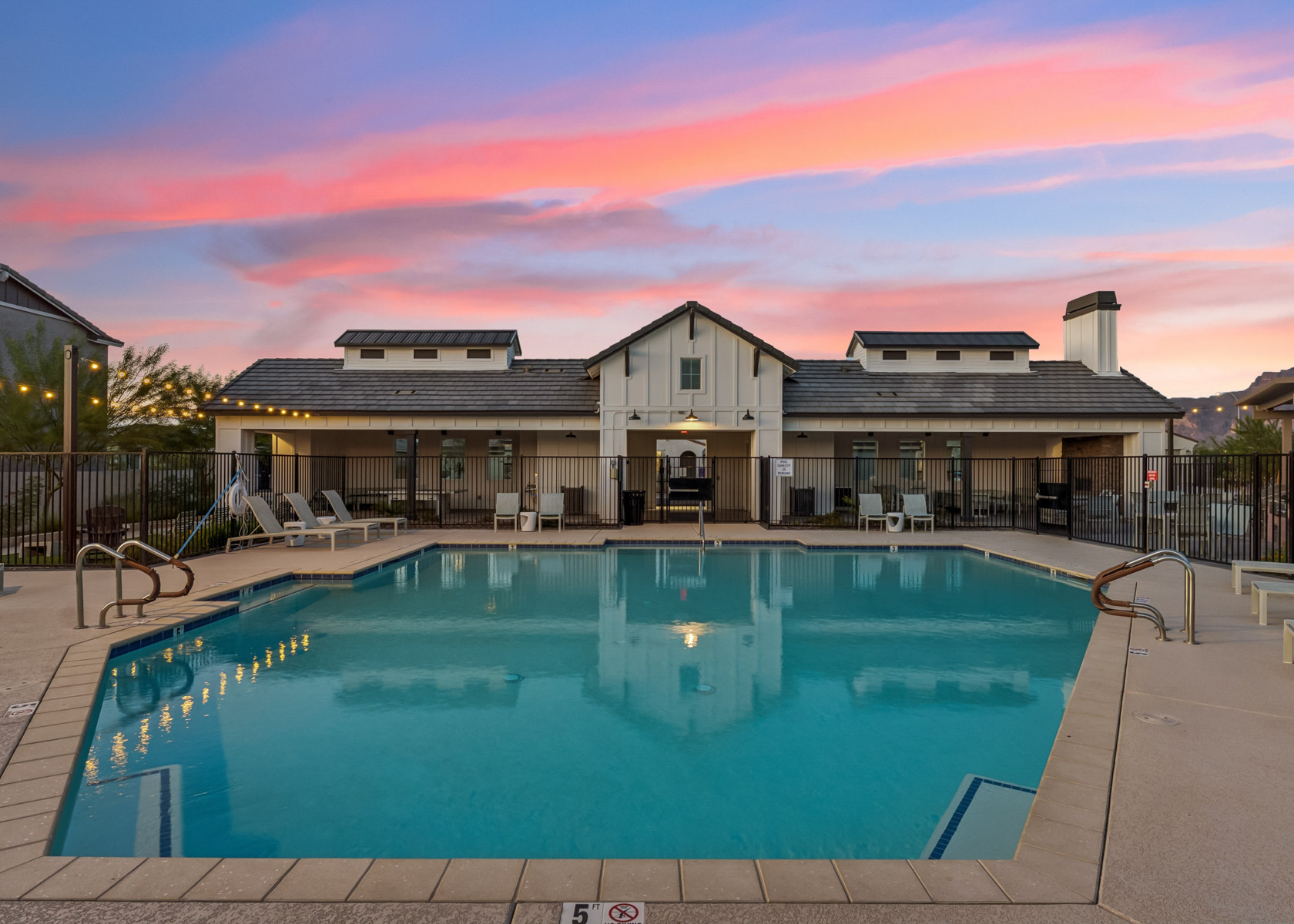 A swimming pool in front of a house.