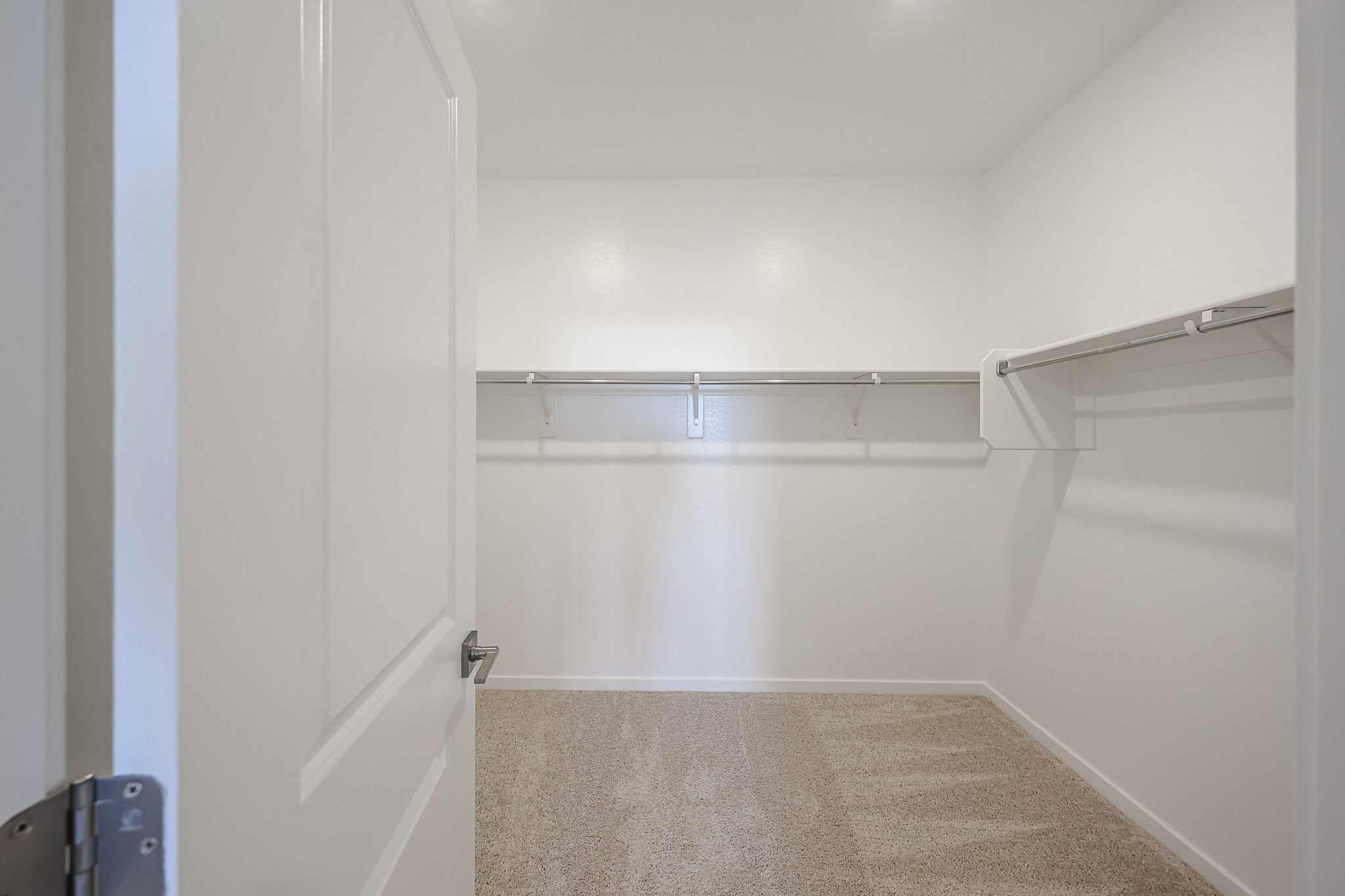 A shower with a metal bar.