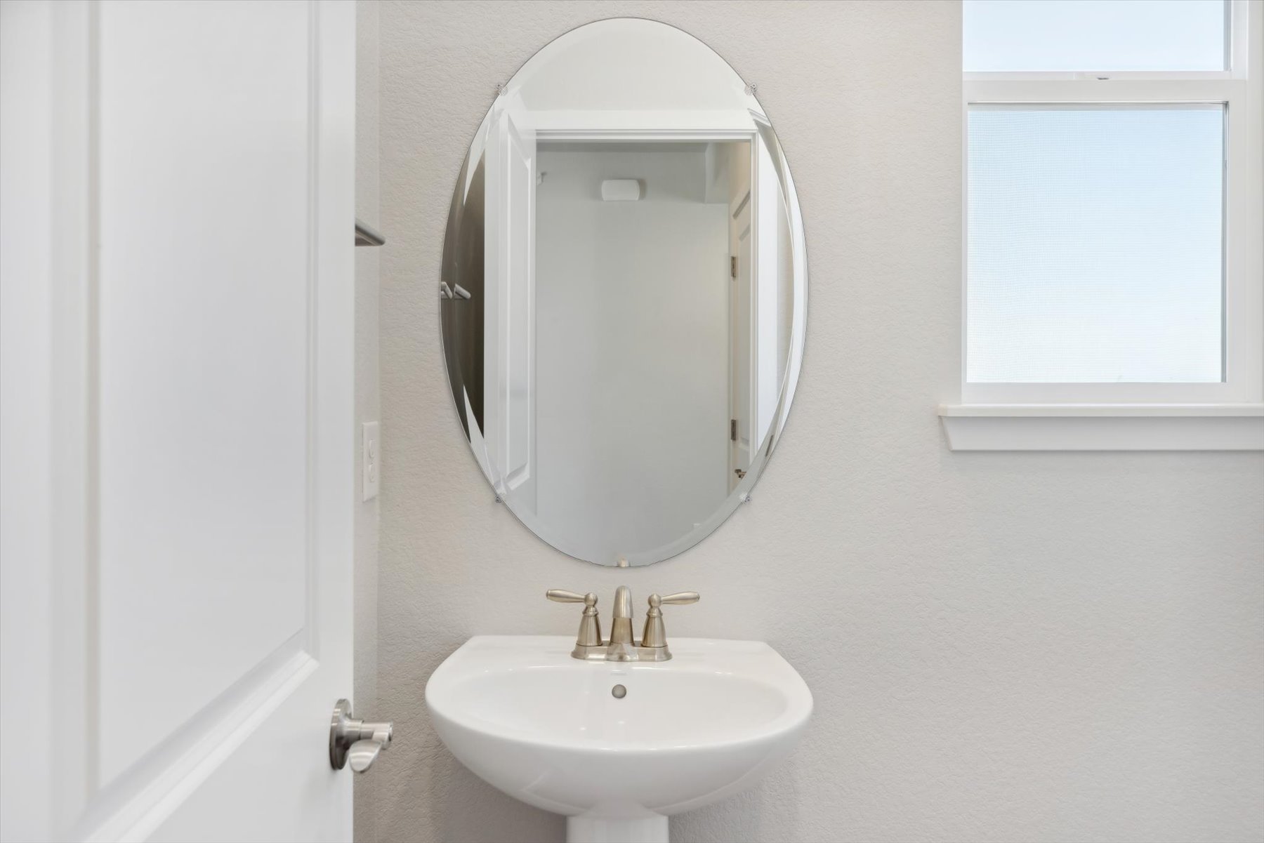 A bathroom with a round mirror.