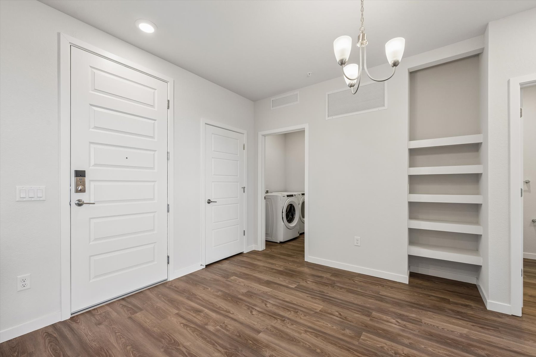 A room with white doors and a wood floor.
