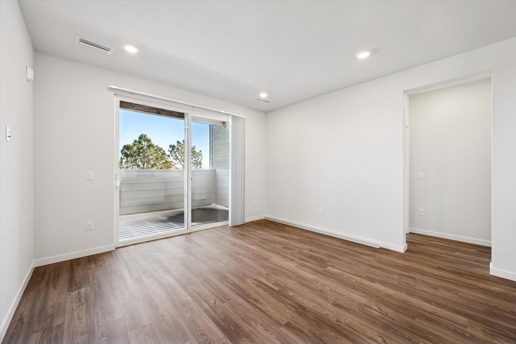 A room with a wood floor and a wood floor with a glass door.