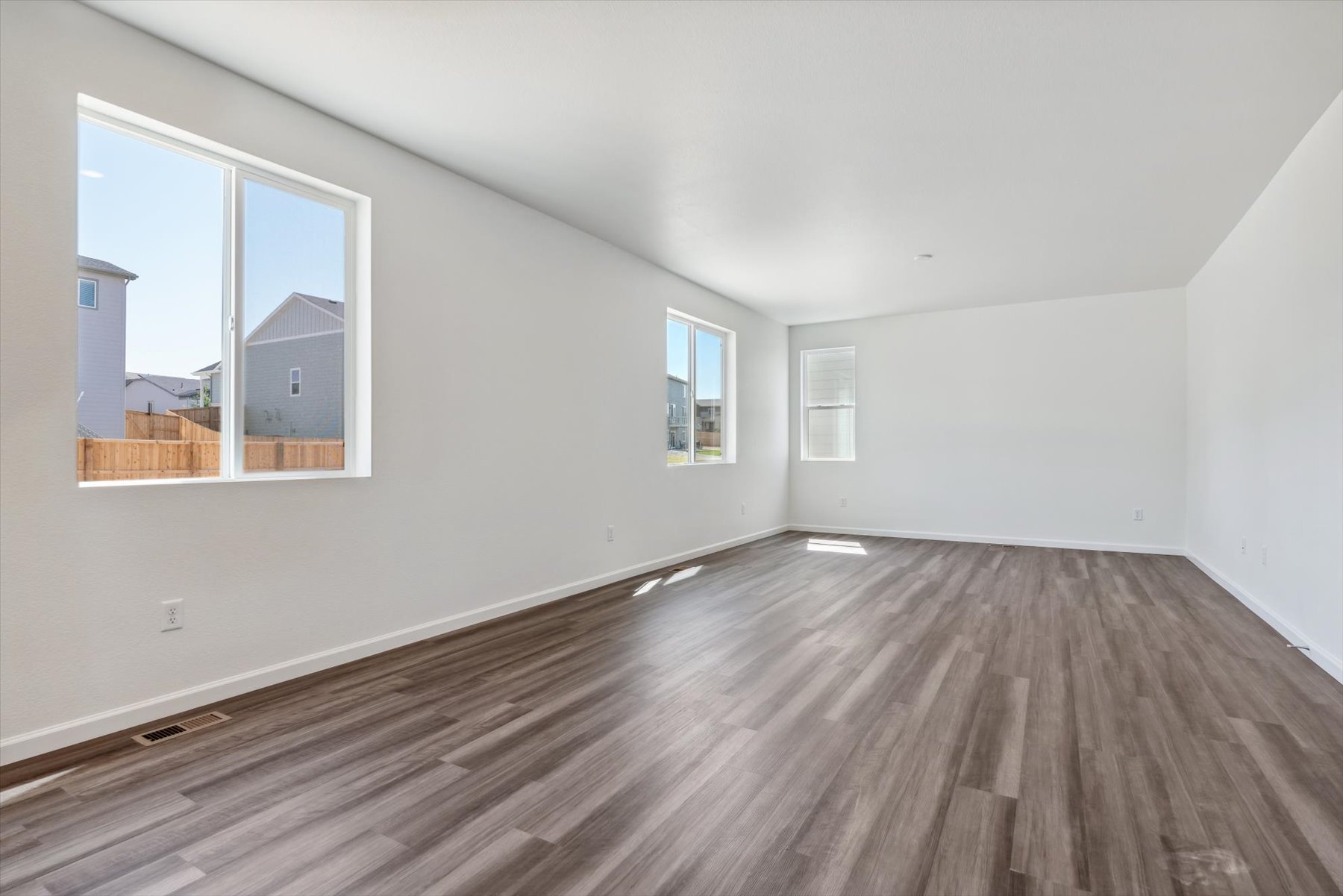 A room with a wood floor and windows.