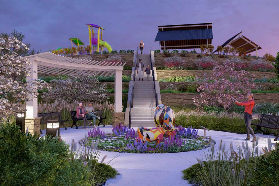 A group of people sitting on a bench in a garden.