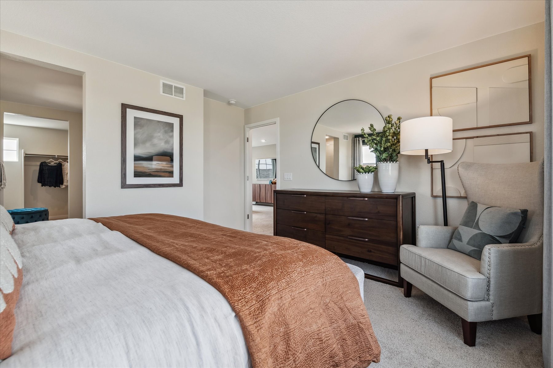 A bedroom with a bed and a chair.