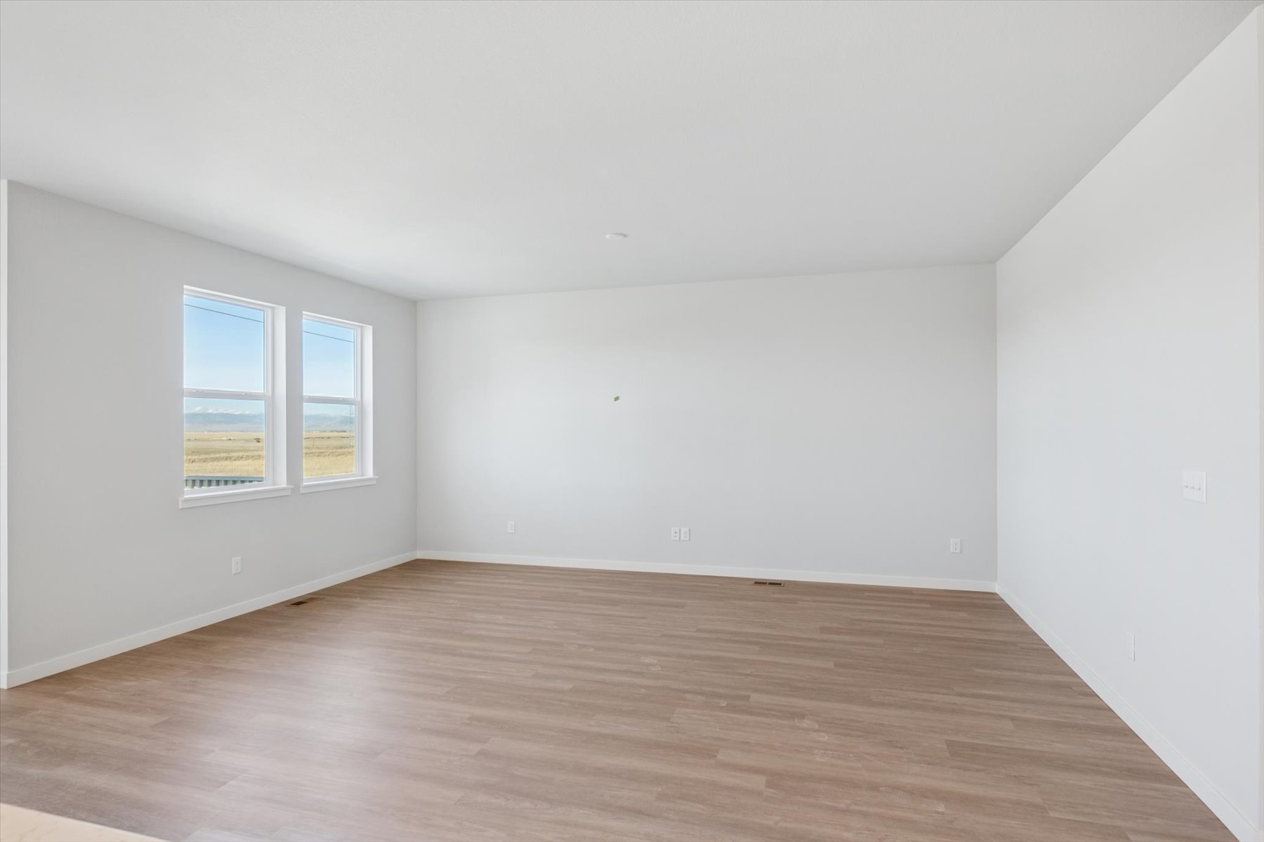 A room with a wood floor and a window.