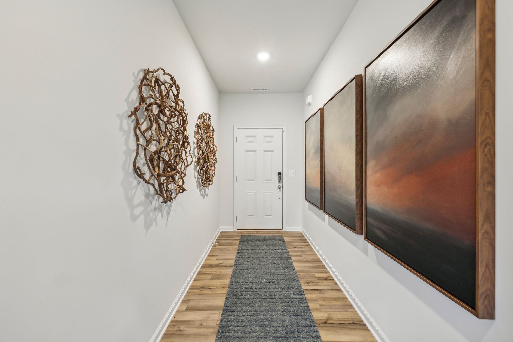 A hallway with a door and a rug.