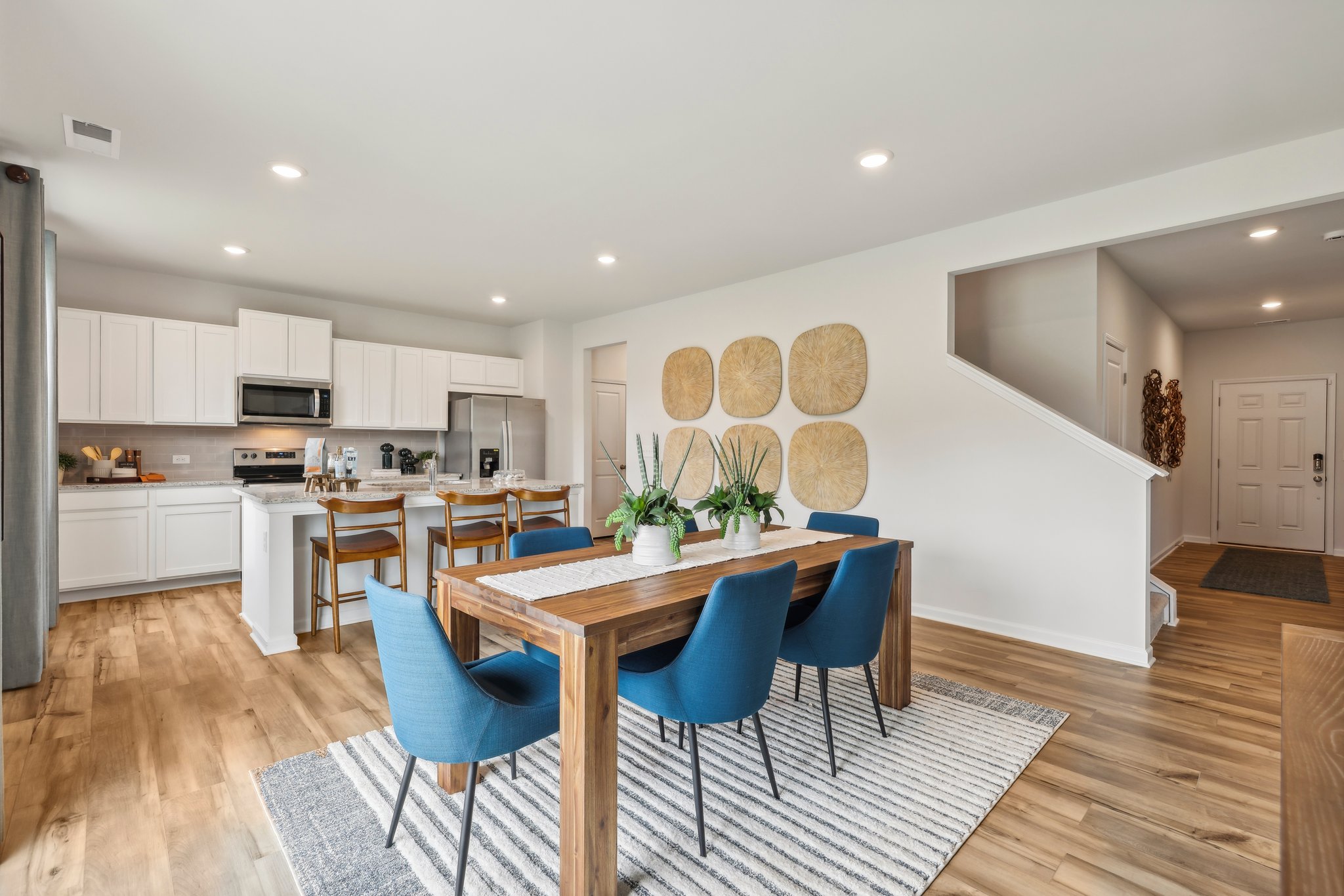 A kitchen with a dining table and chairs.