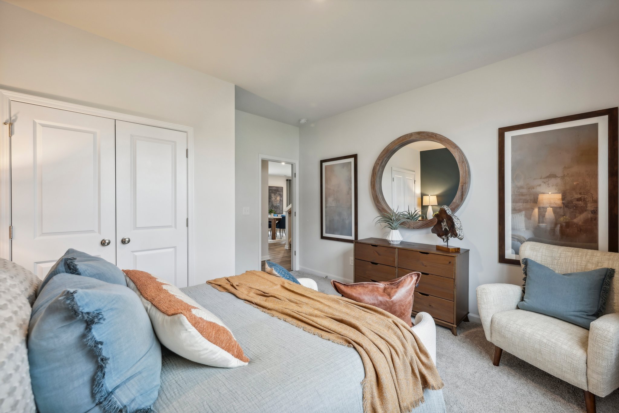 A bedroom with a bed and a mirror.