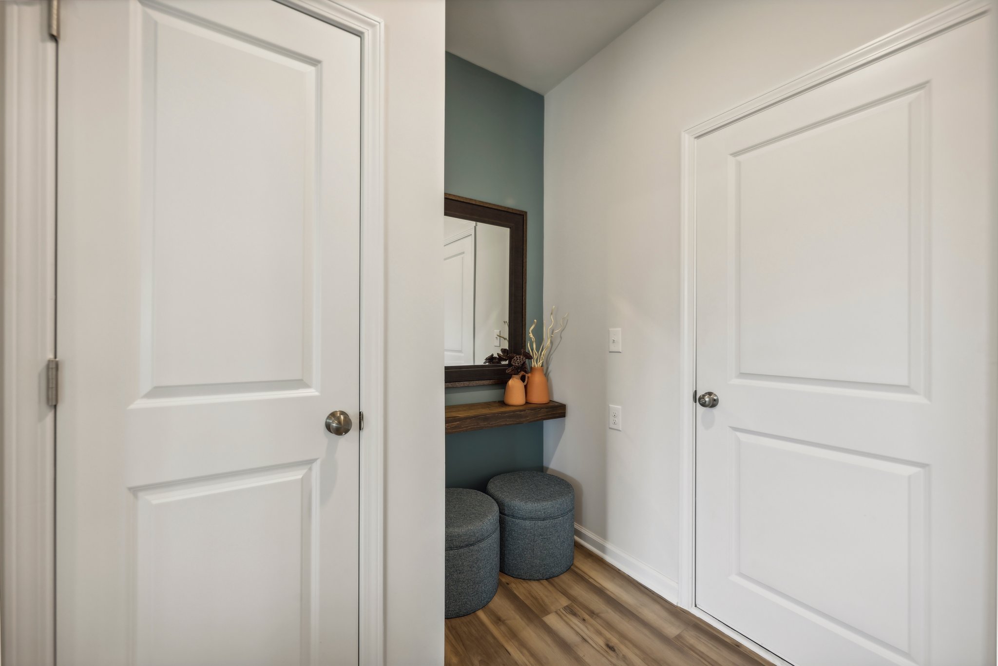 A room with white doors and a table with a plant on it.
