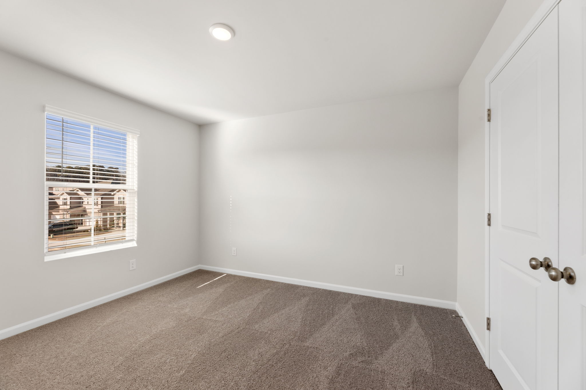 A room with a window and a carpet.