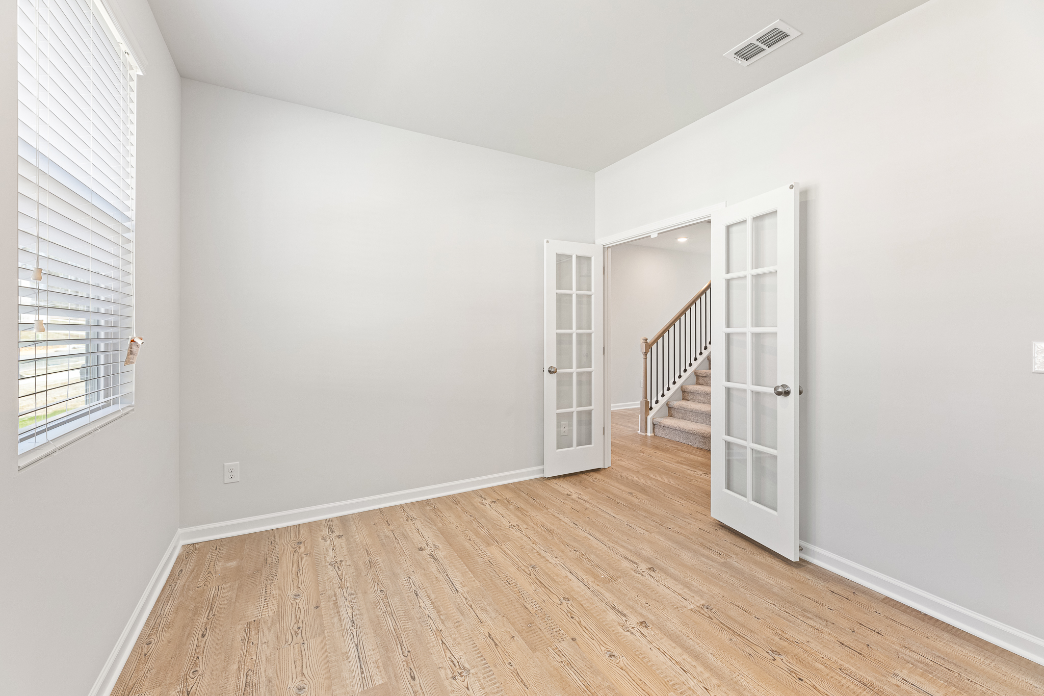 A room with a wood floor and white walls.