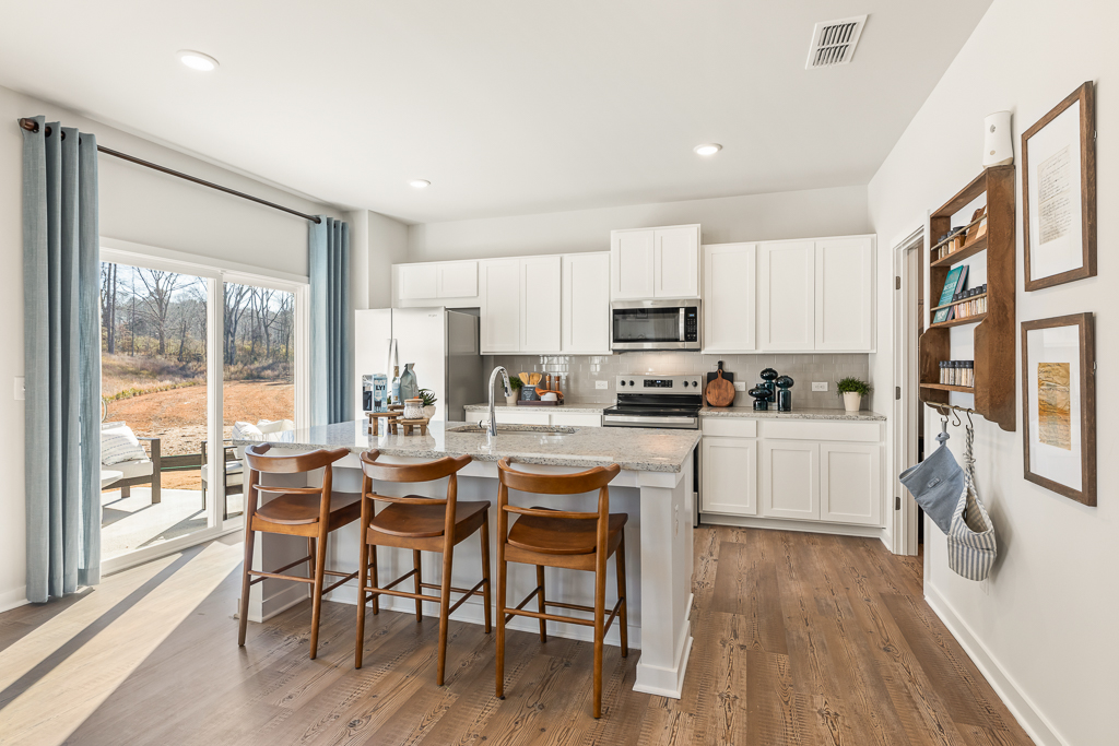 A kitchen with a dining table and chairs.