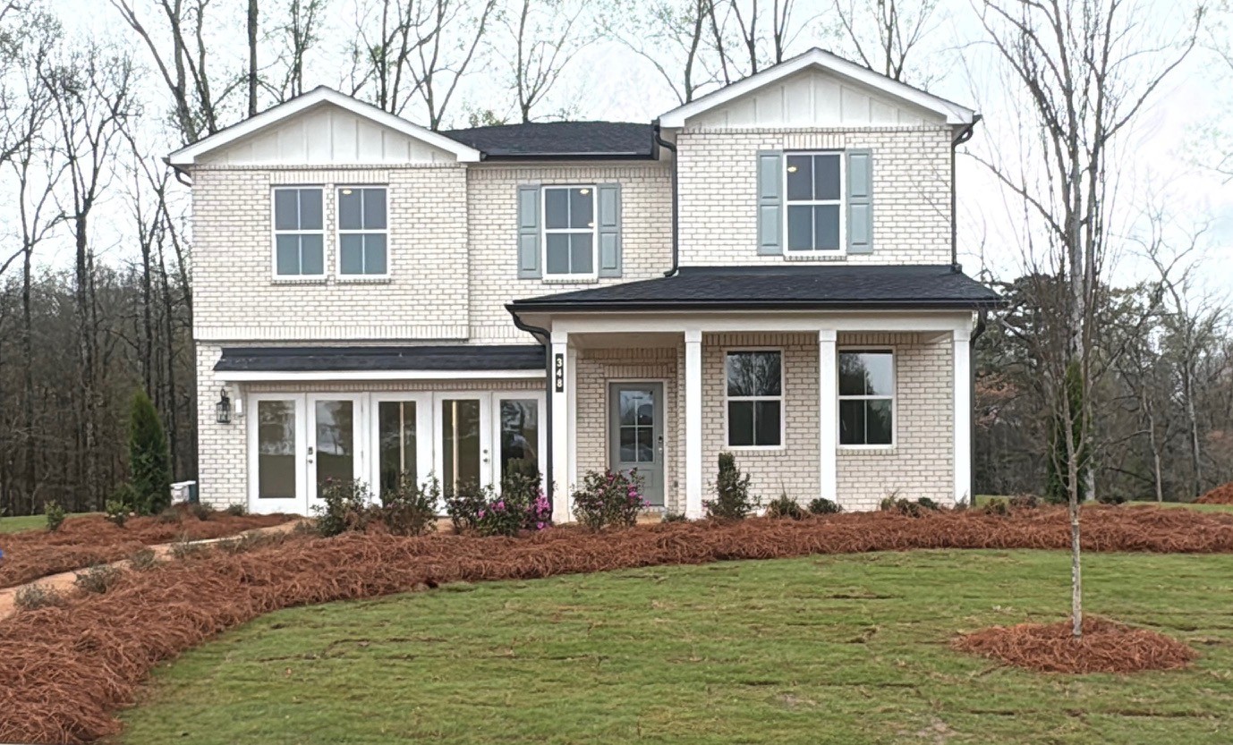 A white house with a lawn with Eisenhower Home in the background.