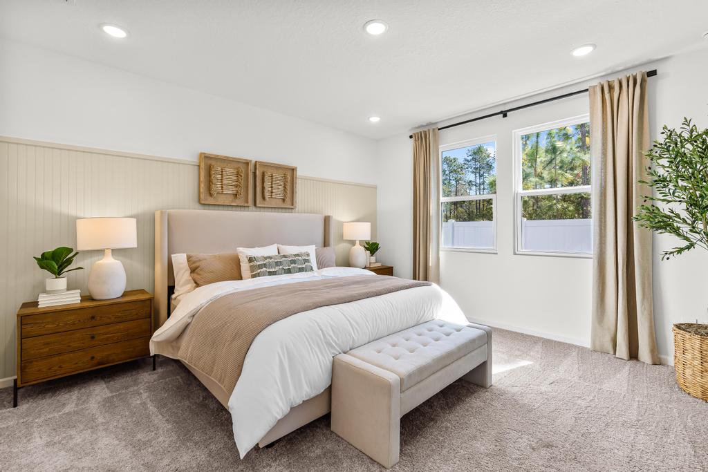 A bedroom with a bed and a bench.