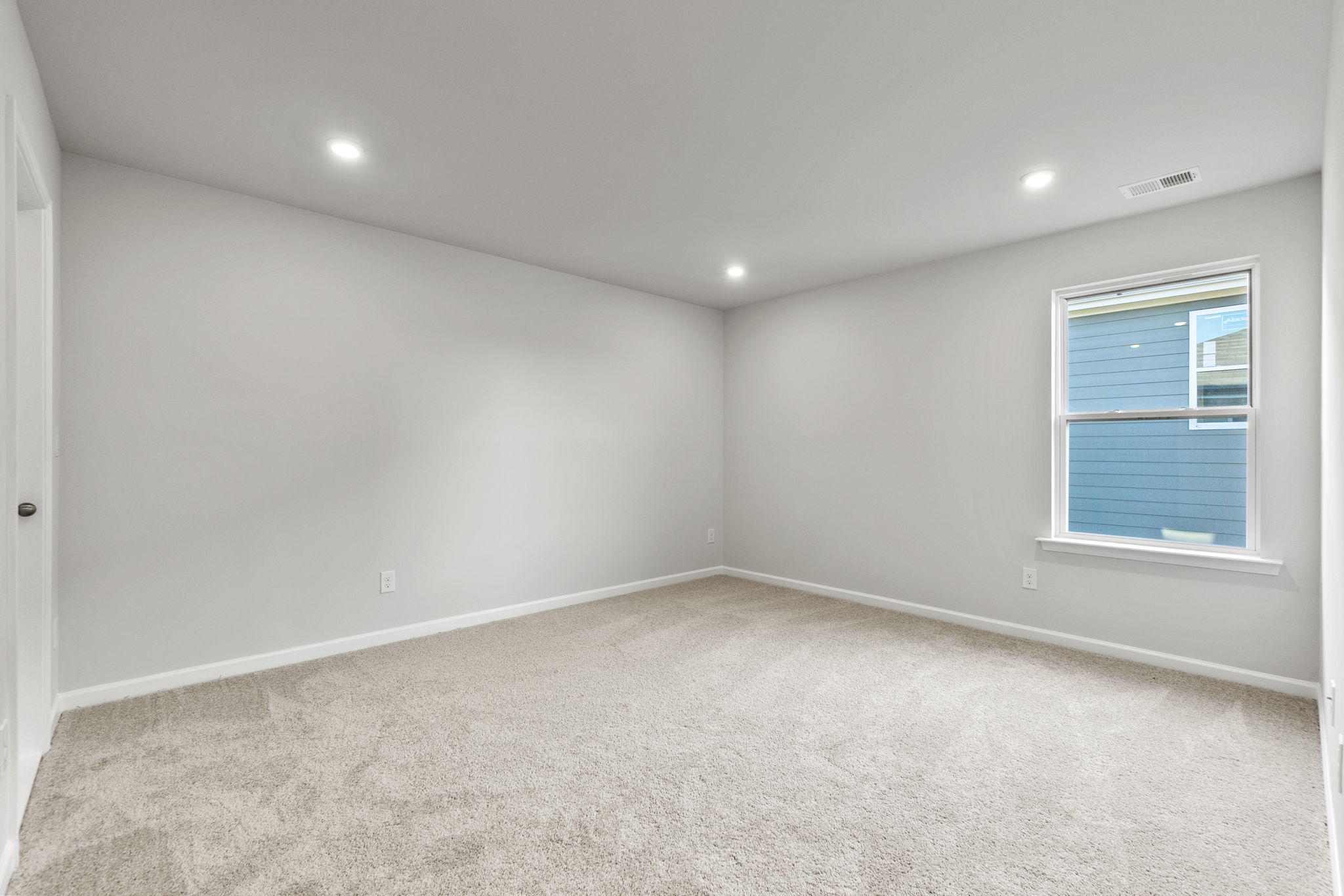 A room with a window and a carpet.