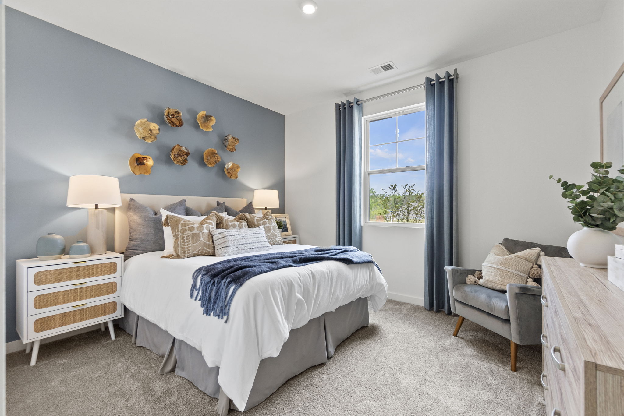 A bedroom with a bed and a chair.