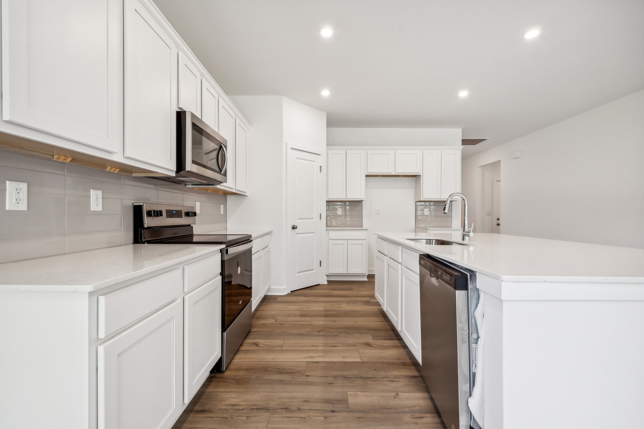 A kitchen with white cabinets.