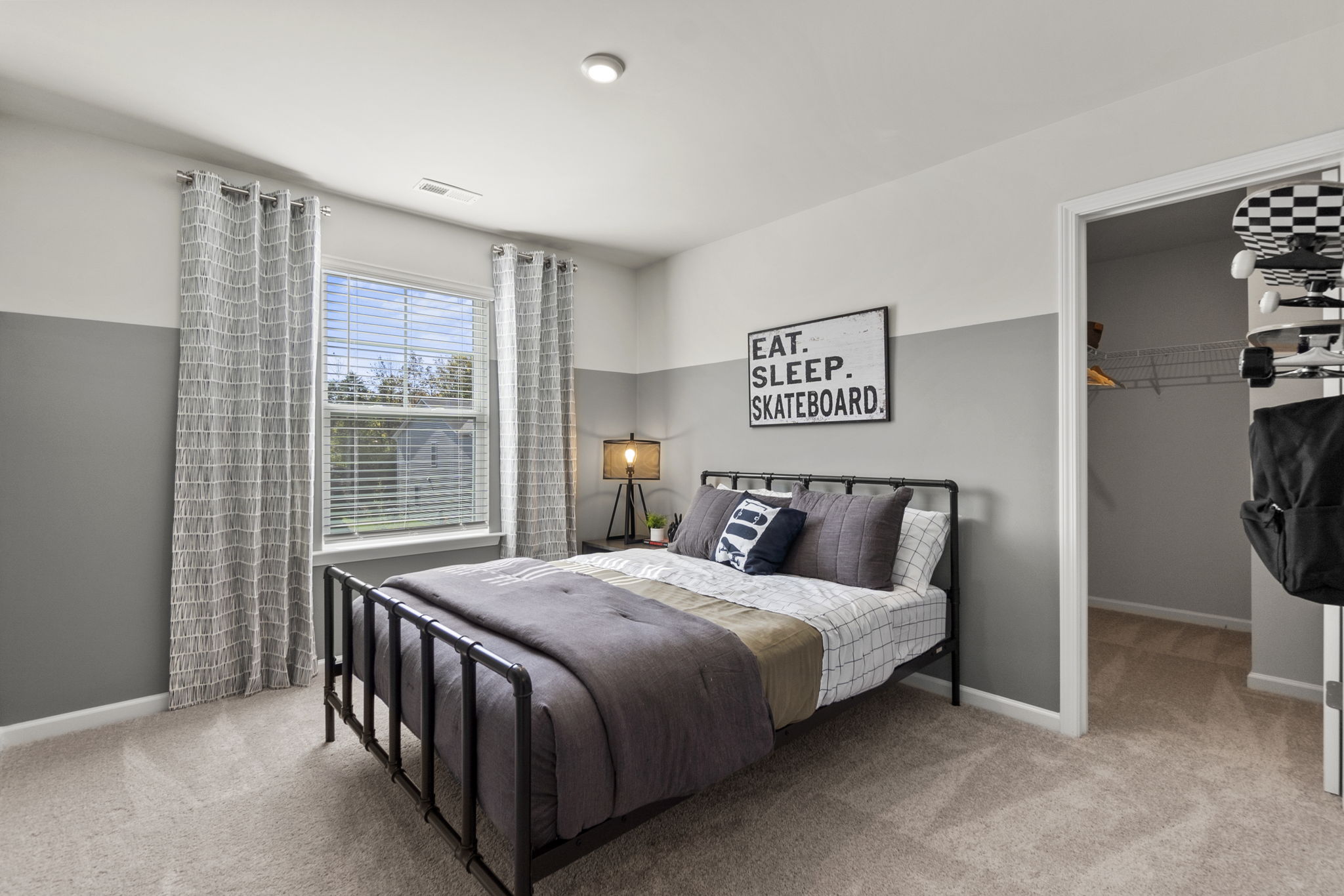 A bedroom with a bed and a lamp.