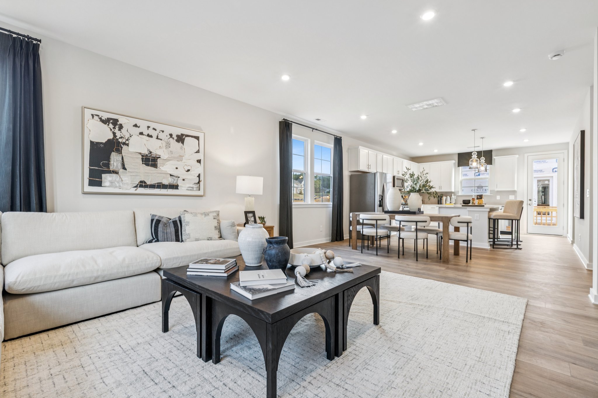 A large living room with a large dining table and a large painting.
