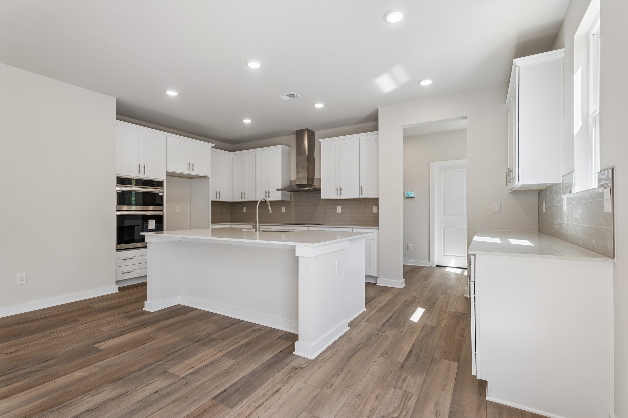 A kitchen with white cabinets.