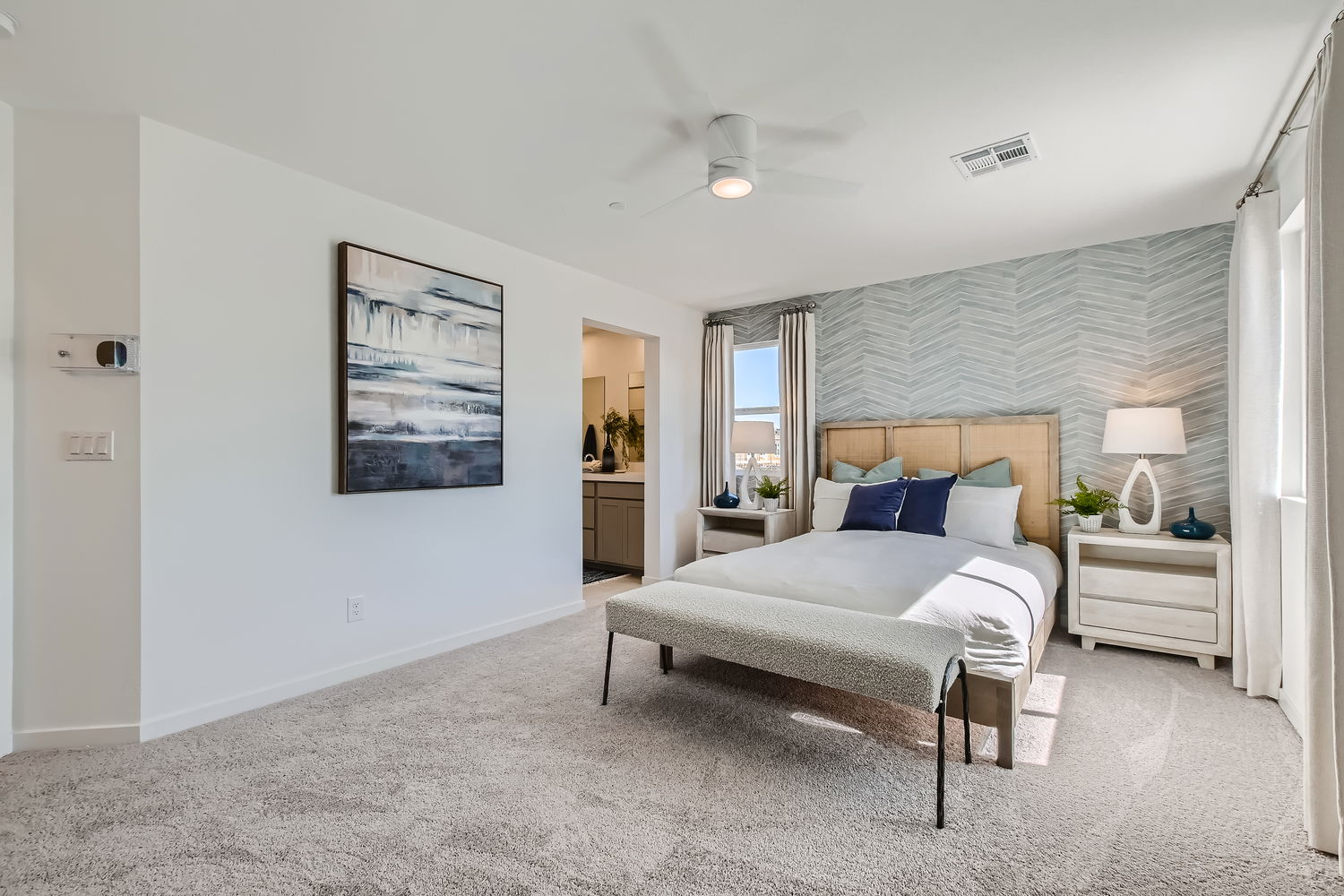 A bedroom with a bed and a lamp.