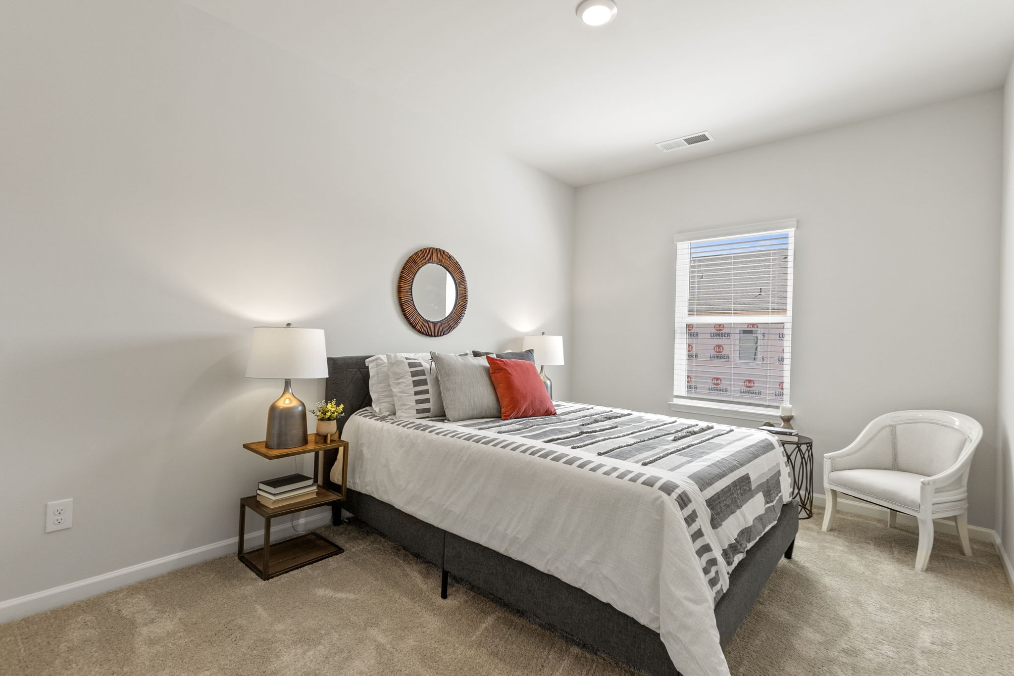 A bedroom with a bed and a chair.