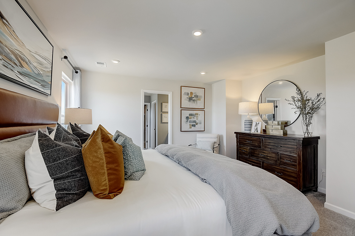 A bedroom with a bed and a mirror.