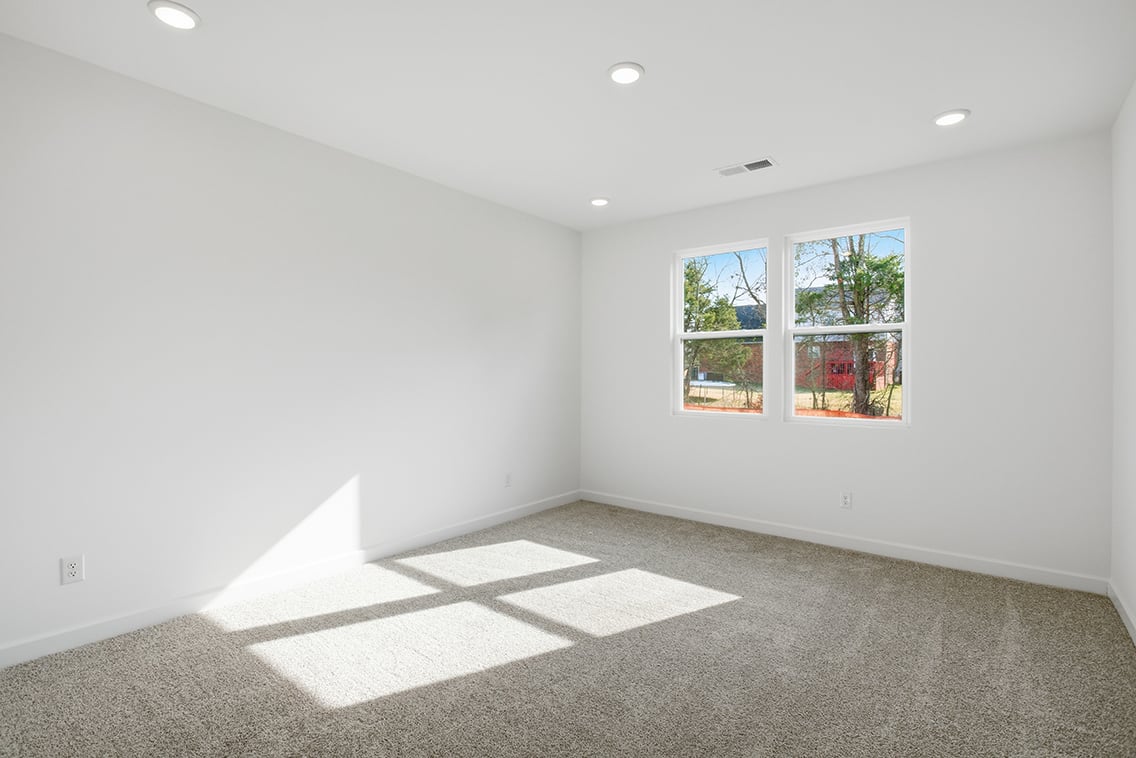 A room with a window and a rug in it.