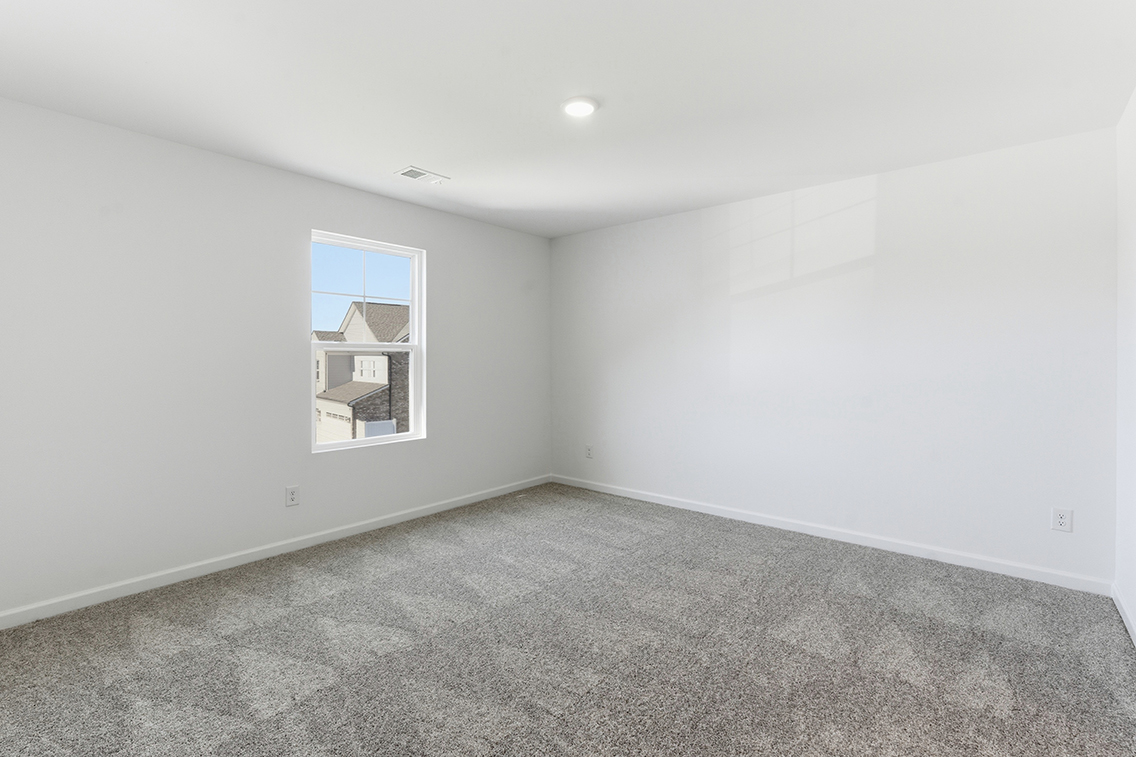 A room with a window and a carpet.