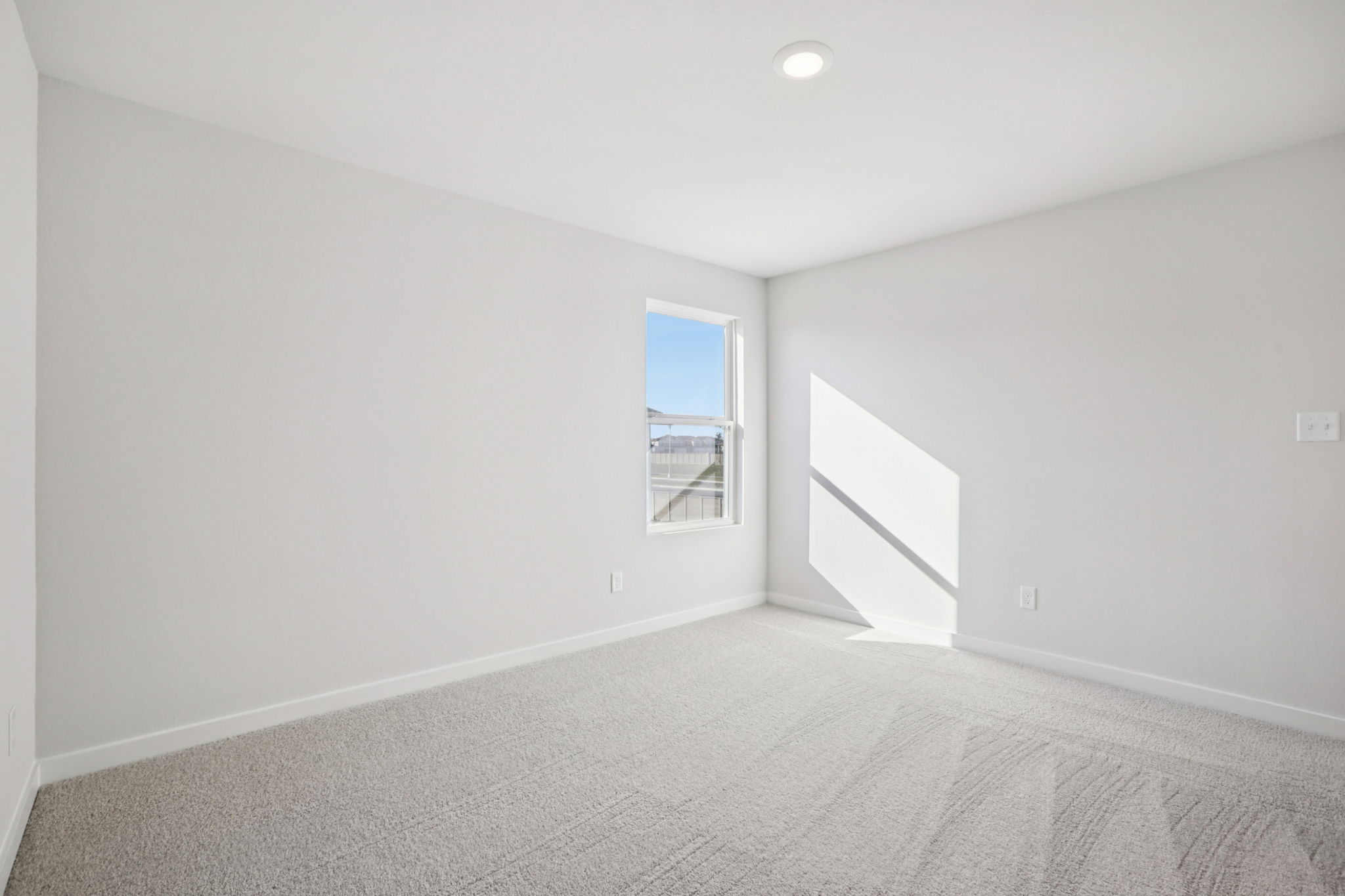 A room with a window and a bed.