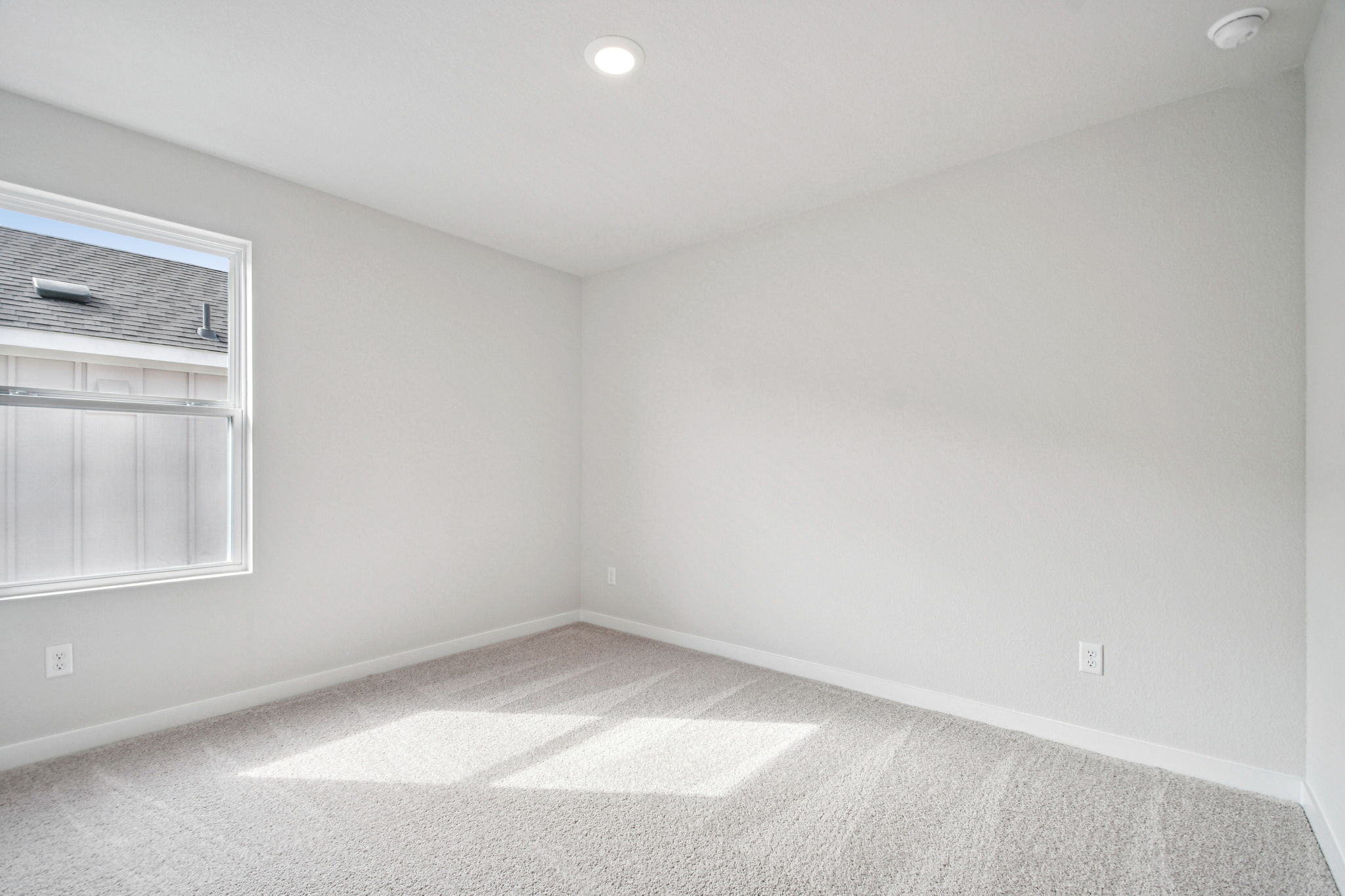 A room with a white wall and a window.