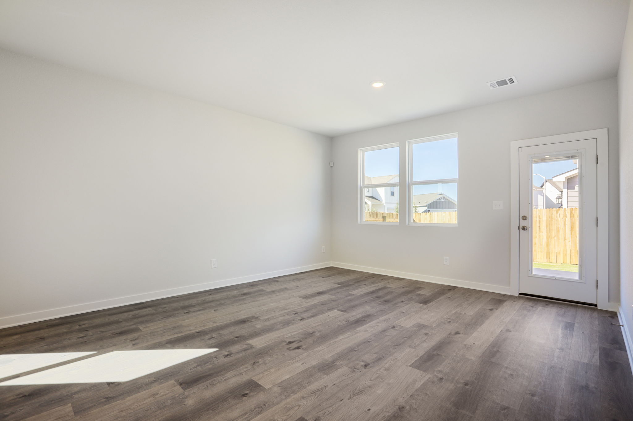 A room with a wood floor and windows.