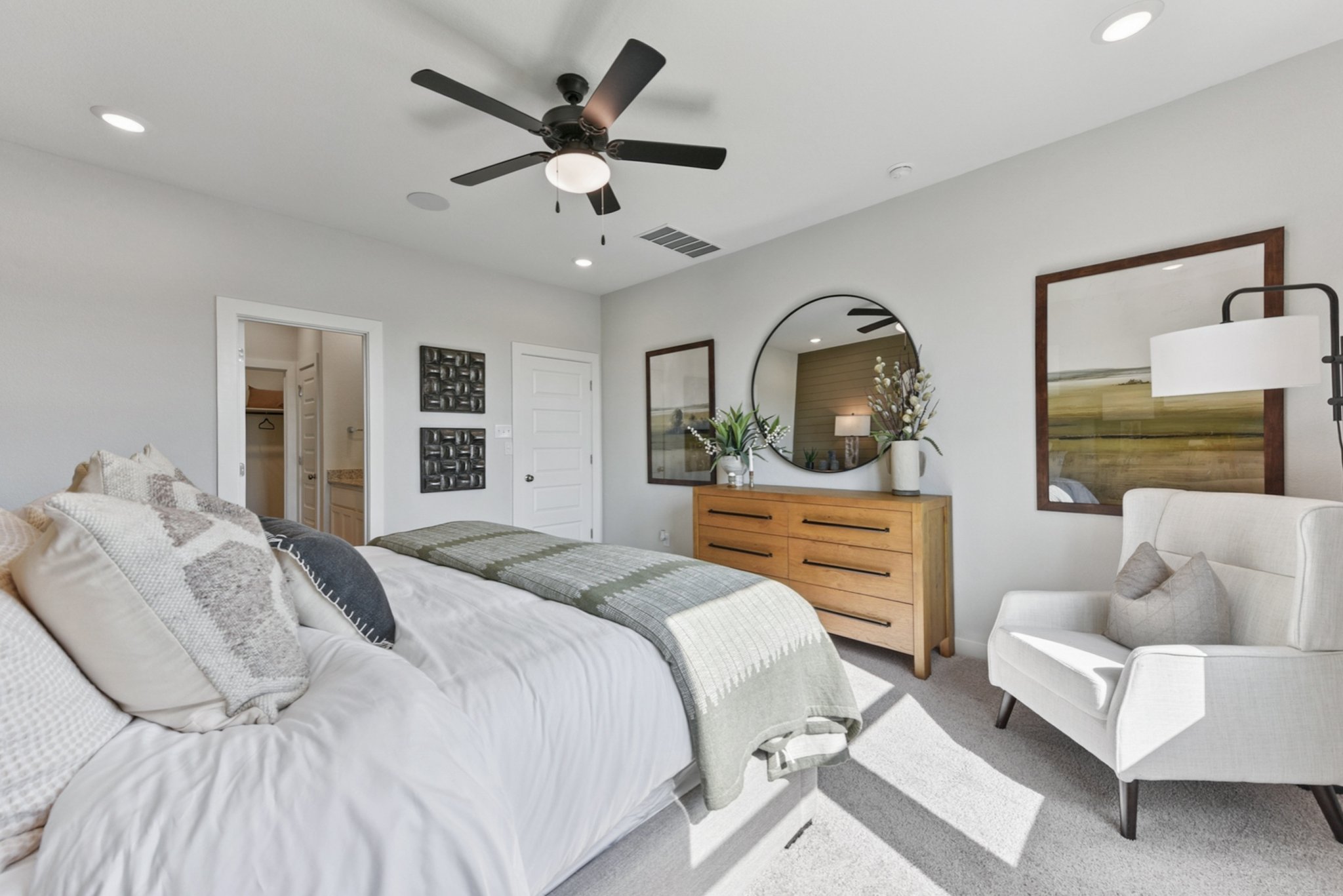 A bedroom with a bed and a fan.