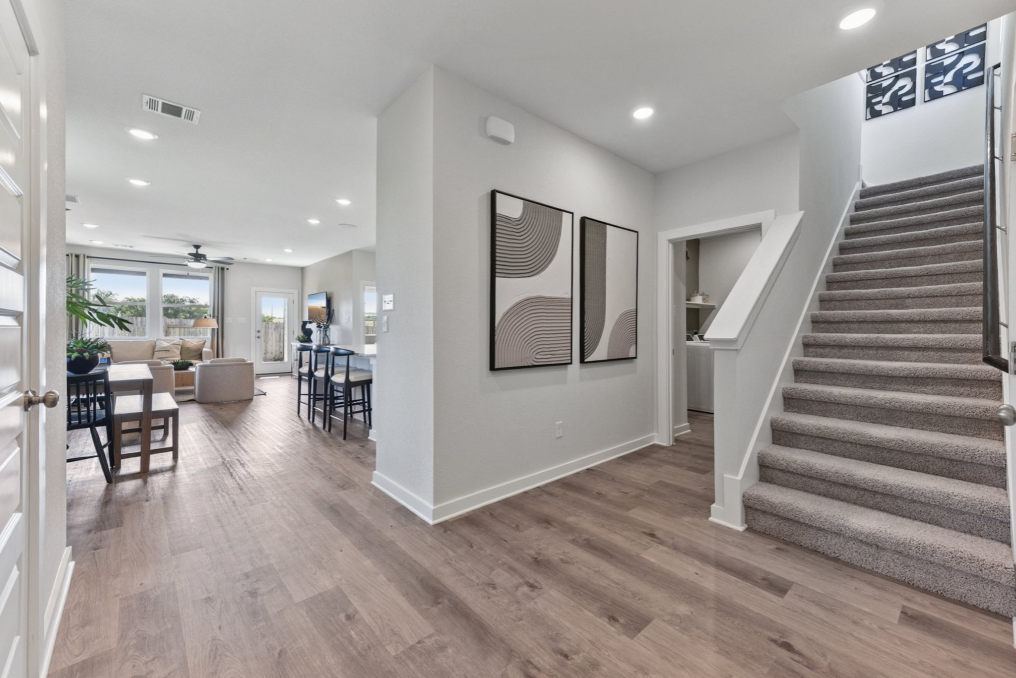 A room with a wood floor and a wood staircase.